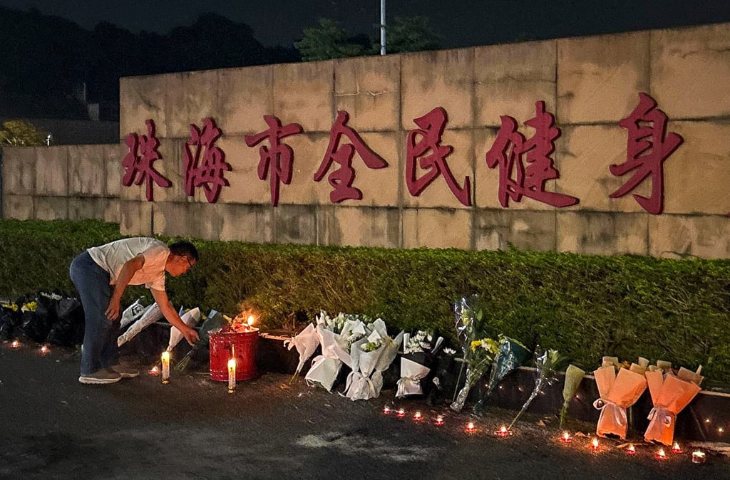 A man looks at candles left outside the Zhuhai Sports Centre, a day after a car rammed through the site killing dozens in Zhuhai. Photo: Amber Wang