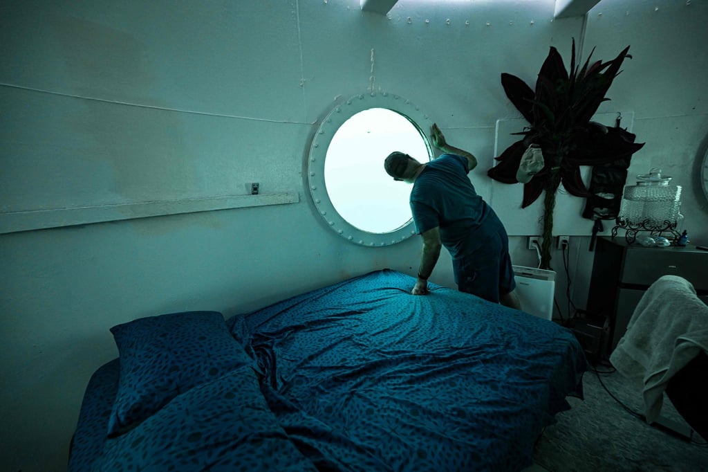 Koch looks through a porthole inside his underwater room off the coast of Puerto Lindo, Panama. Photo: AFP Koch looks through a porthole inside his underwater room off the coast of Puerto Lindo, Panama. Photo: AFP