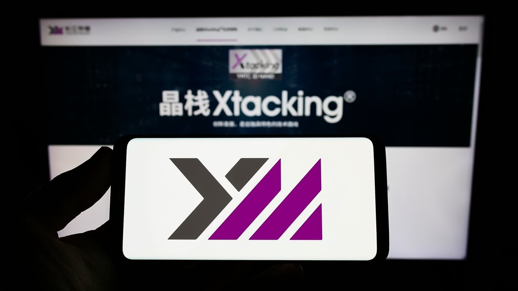 The logo of Yangtze Memory Technologies Corp (YMTC) is pictured on a smartphone screen in front of its website. Photo: Shutterstock Images