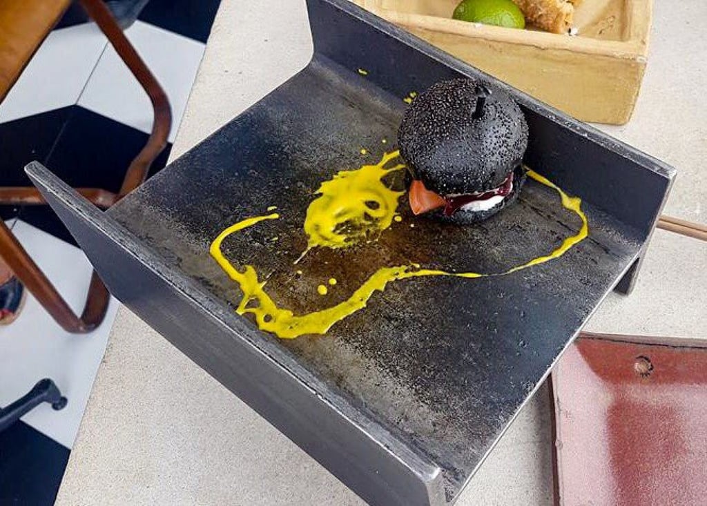 A burger served on a section of I-beam. Photo: We Want Plates/Jon Russell