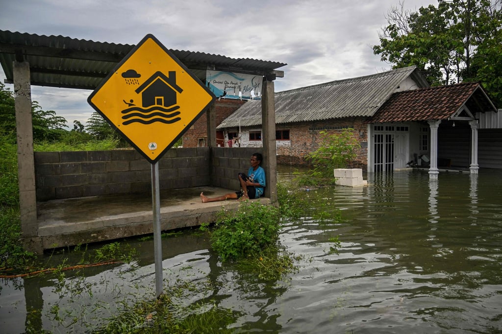 A man in Tempuran village, East Java province, rests in a hut surrounded by floodwaters on Monday. Photo: AFP A man in Tempuran village, East Java province, rests in a hut surrounded by floodwaters on Monday. Photo: AFP