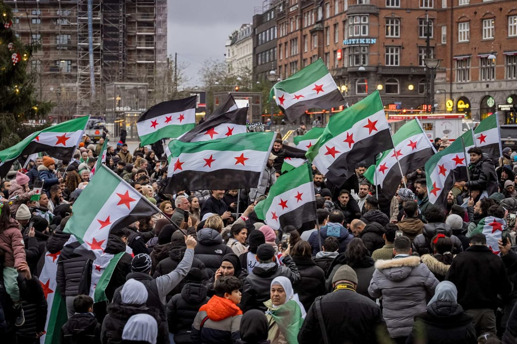 Members of the Syrian community wave Syrian flags in Copenhagen, Denmark on Monday as they rally to celebrate the end of Assad’s rule. Photo: Ritzau Scanpix / AFP