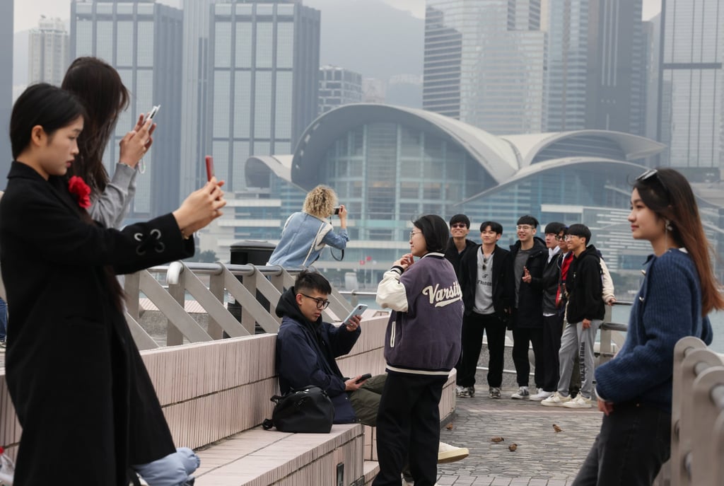 Tourists pose for photos on the Tsim Sha Tsui harbourfront in Hong Kong. Photo: Jelly Tse Tourists pose for photos on the Tsim Sha Tsui harbourfront in Hong Kong. Photo: Jelly Tse