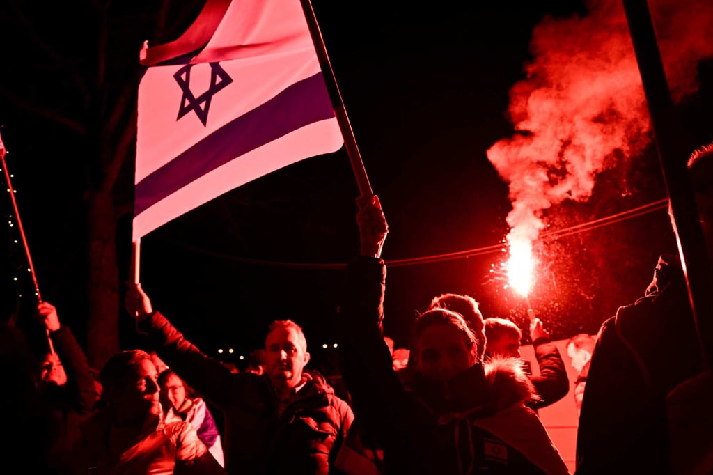 Protesters holding Israeli flags light red flares during a rally against antisemitism in Amsterdam, the Netherlands, in November. Photo: AFP Protesters holding Israeli flags light red flares during a rally against antisemitism in Amsterdam, the Netherlands, in November. Photo: AFP