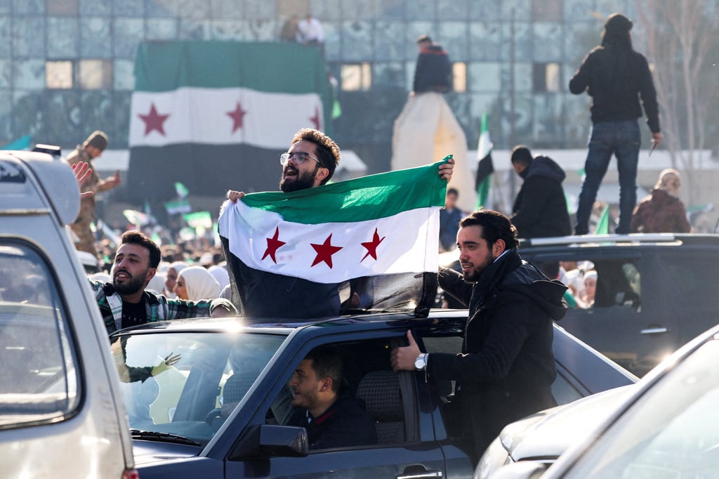 A man in Damascus holds a flag adopted by Syria’s new rulers, Photo: Reuters