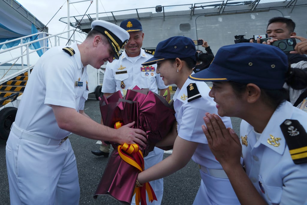 Daniel A. Sledz (left), commanding officer of the USS Savannah, receives a bouquet of flowers from Cambodian naval personnel at Sihanoukville port on Monday. Photo: AP