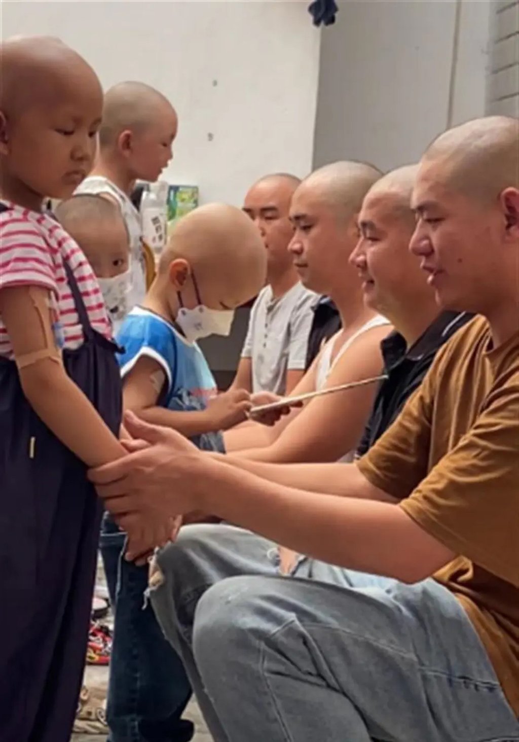The fathers shaved their heads to make their children feel better while they battle cancer. Photo: QQ.com The fathers shaved their heads to make their children feel better while they battle cancer. Photo: QQ.com