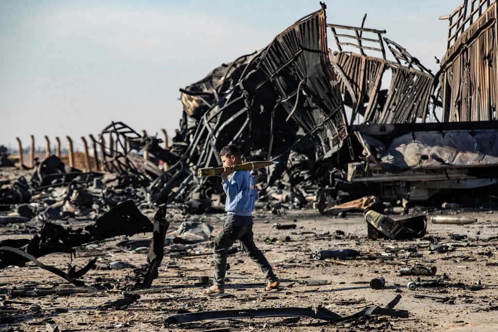 A boy carries an unexploded rocket propelled grenade at the site of an Israeli airstrike that targeted weapons shipments in Qamishli, northeastern Syria, on December 10. Photo: AFP A boy carries an unexploded rocket propelled grenade at the site of an Israeli airstrike that targeted weapons shipments in Qamishli, northeastern Syria, on December 10. Photo: AFP
