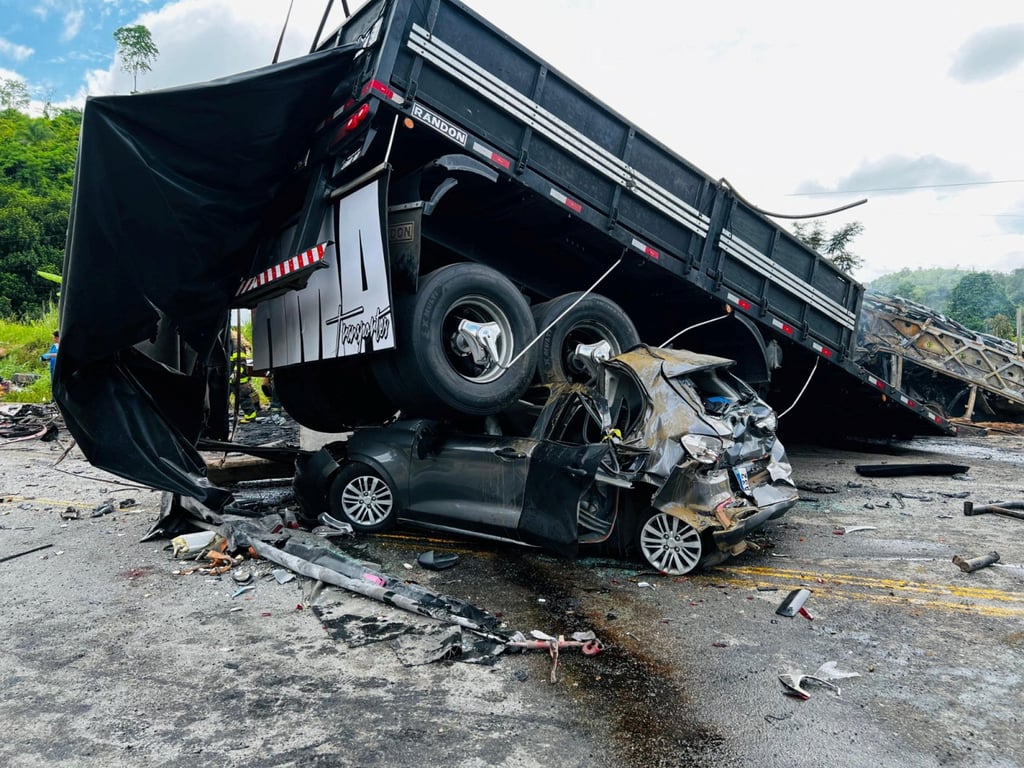 A damaged car is crushed under a vehicle following a traffic accident after a packed bus collided with a truck on the Fernao Dias national highway in Brazil. Photo: via Reuters A damaged car is crushed under a vehicle following a traffic accident after a packed bus collided with a truck on the Fernao Dias national highway in Brazil. Photo: via Reuters