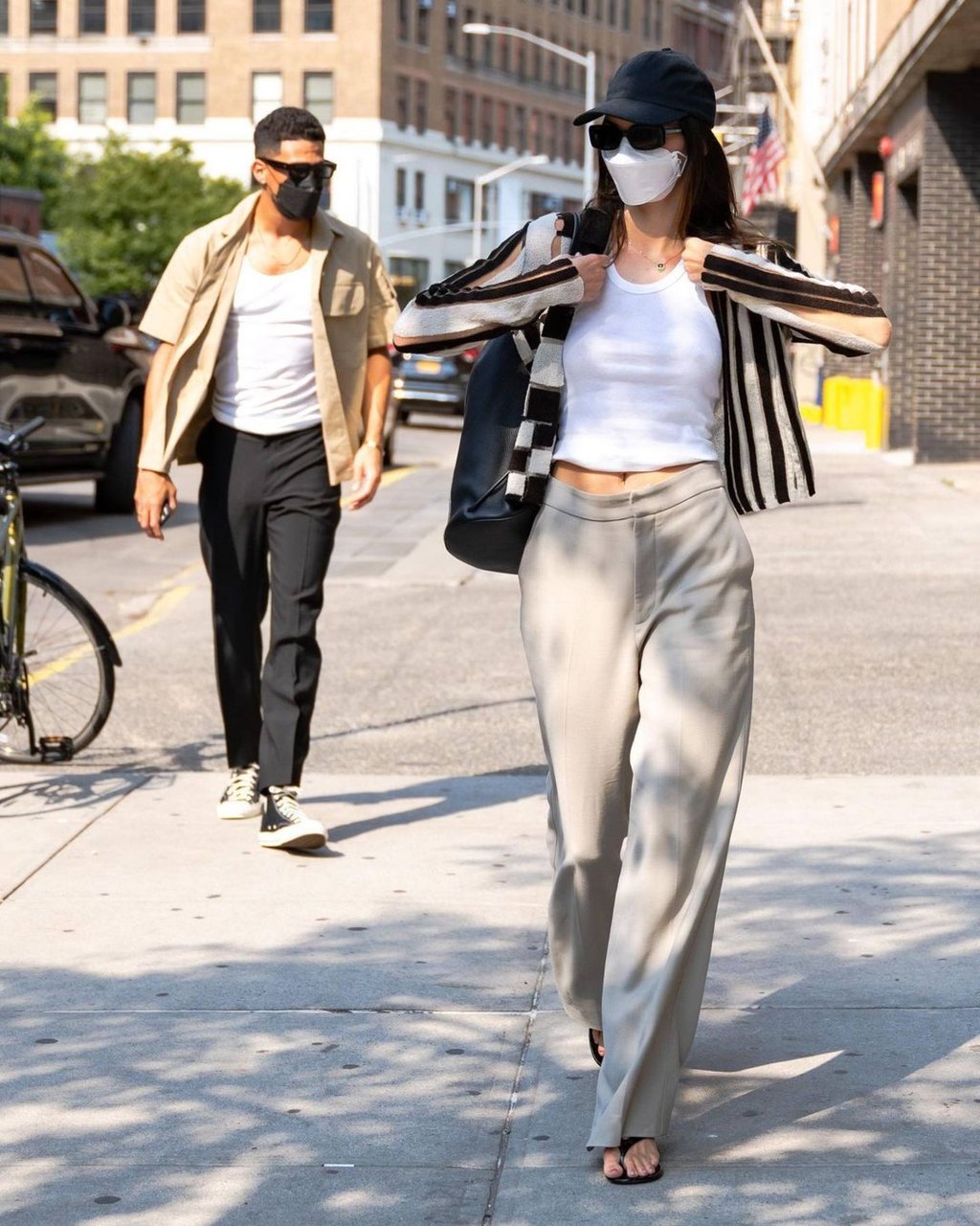 Devin Booker, wearing an open tan shirt and black trousers, with then-girlfriend Kendall Jenner, in September 2021. Photo: @leaguefits/Instagram