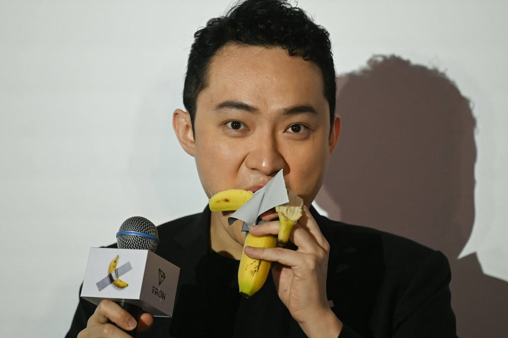 Chinese-born cryptocurrency founder Justin Sun eats “Comedian”, an artwork composed of a fresh banana stuck to a wall with duct tape, in Hong Kong on November 29. Photo: AFP