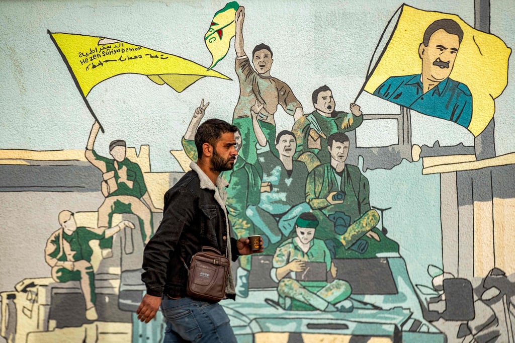 A man walks past a mural depicting supporters of the Syrian Democratic Forces (SDF), one of them raising a flag showing the face of Abdullah Ocalan, in Qamishli, northeastern Syria. Photo: AFP A man walks past a mural depicting supporters of the Syrian Democratic Forces (SDF), one of them raising a flag showing the face of Abdullah Ocalan, in Qamishli, northeastern Syria. Photo: AFP