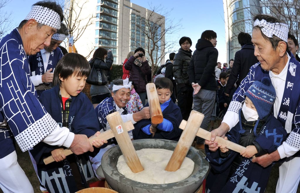 Children pound steamed rice into cake during the annual mochi-tsuki event in Tokyo. Photo: AFP Children pound steamed rice into cake during the annual mochi-tsuki event in Tokyo. Photo: AFP
