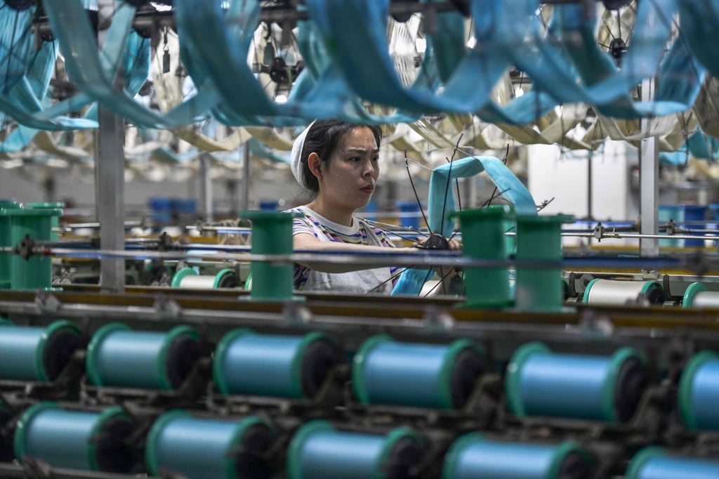 A worker produces silk products at a textile factory in Fuyang, in eastern China’s Anhui province. China’s PMI gauge of the manufacturing sector was up in December. Photo: AFP