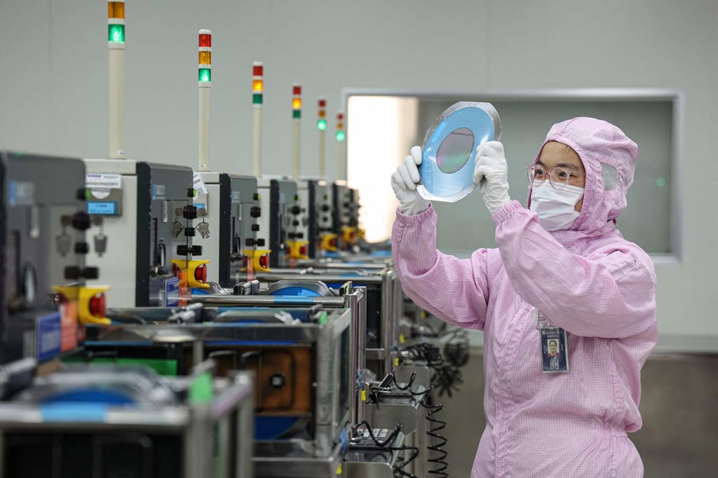 An employee inspects a silicon wafer at a facility in Binzhou, in eastern China’s Shandong province. Photo: AFP An employee inspects a silicon wafer at a facility in Binzhou, in eastern China’s Shandong province. Photo: AFP