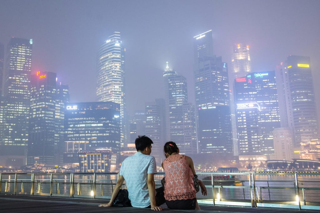 A couple relaxes on the boardwalk along Marina Bay in Singapore, another city with a famous harbour. Photo: EPA A couple relaxes on the boardwalk along Marina Bay in Singapore, another city with a famous harbour. Photo: EPA