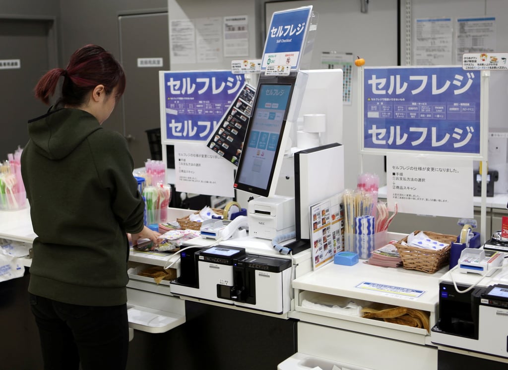 A shopper uses an unmanned cash register at a Lawson outlet in Tokyo. Photo: Reuters