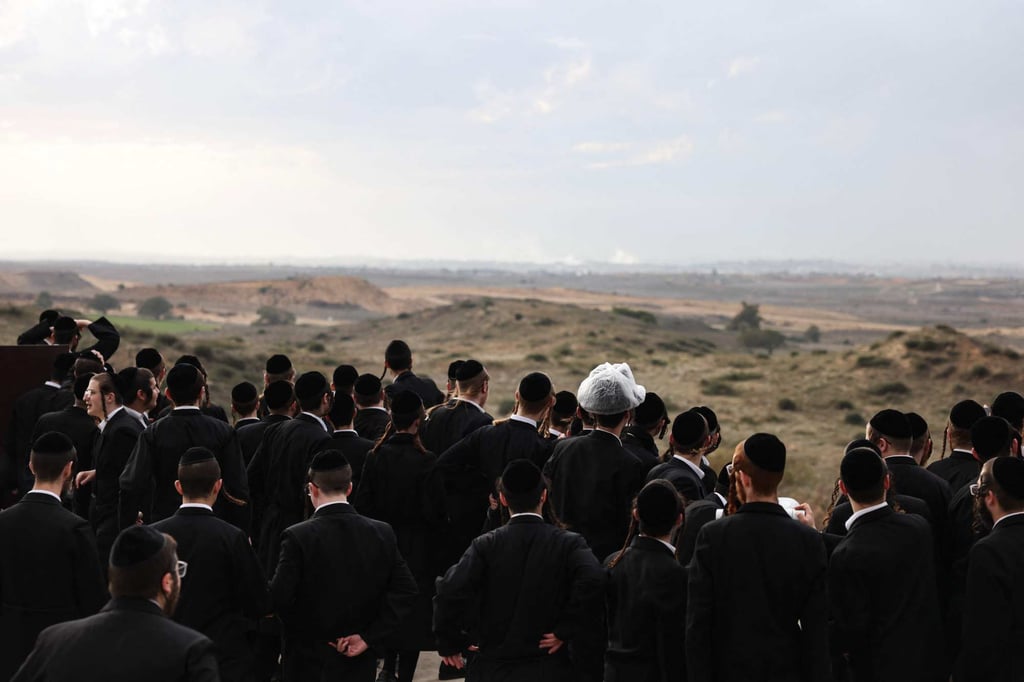 Israeli ultra-Orthodox Jewish men gather on a hill in the southern city of Sderot, and watch as Israeli forces bombard the northern Gaza Strip. Photo: AFP Israeli ultra-Orthodox Jewish men gather on a hill in the southern city of Sderot, and watch as Israeli forces bombard the northern Gaza Strip. Photo: AFP
