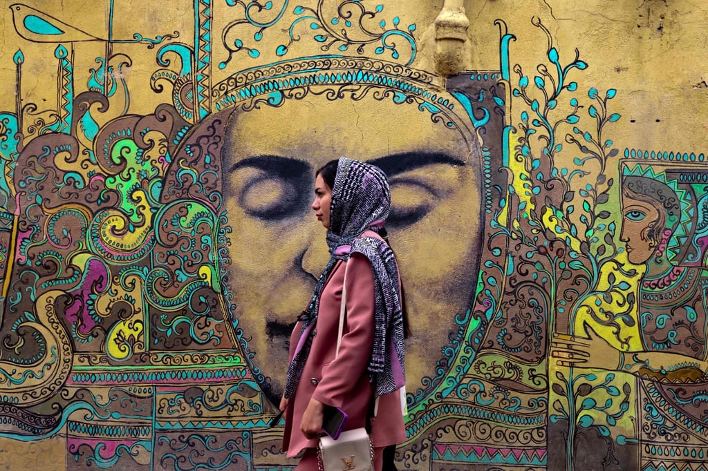 A woman walks past a mural by Yazdi in Narenjestan. Photo: AFP A woman walks past a mural by Yazdi in Narenjestan. Photo: AFP