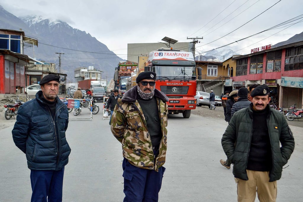 Police personnel stand guard as trucks lie stranded along the Karakoram Highway, blocked by residents on January 6, 2025. Photo: AFP Police personnel stand guard as trucks lie stranded along the Karakoram Highway, blocked by residents on January 6, 2025. Photo: AFP