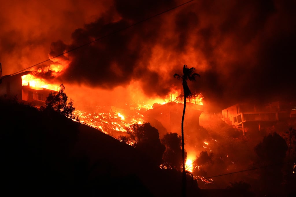 A wildfire burns homes on a hilltop in the Pacific Palisades neighbourhood of Los Angeles. Photo: AP A wildfire burns homes on a hilltop in the Pacific Palisades neighbourhood of Los Angeles. Photo: AP
