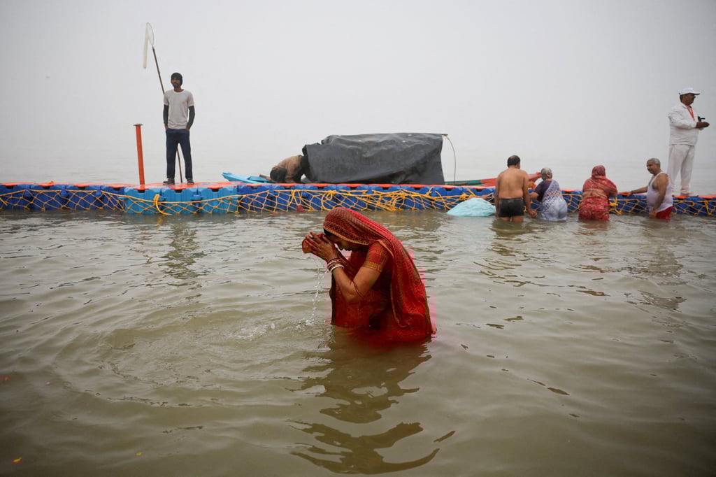 A Hindu devotee takes a holy dip at Sangam, the confluence of the Ganges and Yamuna rivers with the mythical, invisible Saraswati river, during the Maha Kumbh Mela in Prayagraj, India, on January 13, 2025. Photo: Reuters
