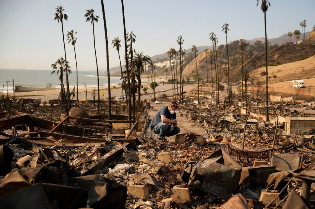 A man sifts through his mother’s fire-ravaged property in the Pacific Palisades neighbourhood of Los Angeles. Photo: AP A man sifts through his mother’s fire-ravaged property in the Pacific Palisades neighbourhood of Los Angeles. Photo: AP