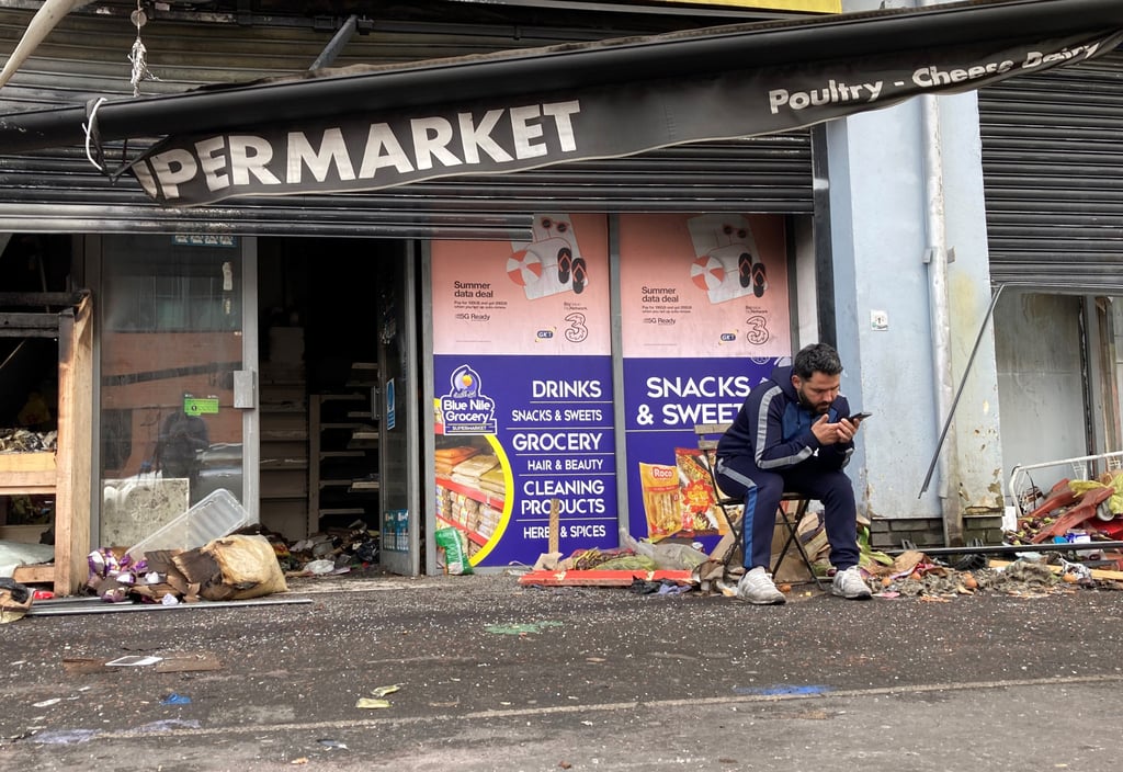 An owner of a destroyed supermarket sits outside his shop on Donegall Road in Belfast, Northern Ireland, on August 6, 2024. The shop was burned during disorder in the area following an anti-immigration protest. Photo: dpa An owner of a destroyed supermarket sits outside his shop on Donegall Road in Belfast, Northern Ireland, on August 6, 2024. The shop was burned during disorder in the area following an anti-immigration protest. Photo: dpa