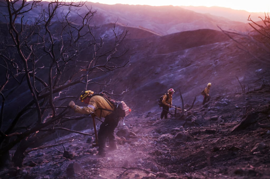 A crew works to mop up hotspots near Mulholland Drive. Photo: Reuters