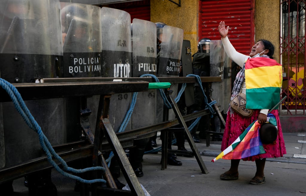 Police block a road to the presidential palace as a supporter of former president Evo Morales shouts during an anti-government protest in La Paz, Bolivia, on Monday. Photo: AP Police block a road to the presidential palace as a supporter of former president Evo Morales shouts during an anti-government protest in La Paz, Bolivia, on Monday. Photo: AP