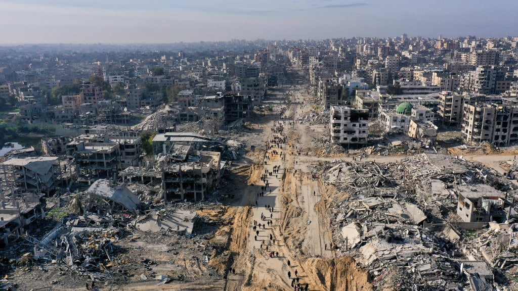 Displaced Palestinians walk past rubble in Gaza as they attempt to return to home on Sunday, amid a ceasefire between Israel and Hamas. Photo: Reuters Displaced Palestinians walk past rubble in Gaza as they attempt to return to home on Sunday, amid a ceasefire between Israel and Hamas. Photo: Reuters