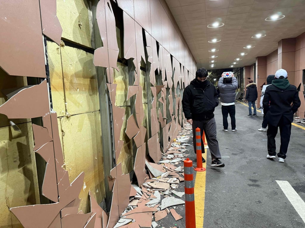 Supporters of impeached South Korean President Yoon Suk-yeol walk past a destroyed wall at the Seoul Western District Court on Sunday. Photo: AFP Supporters of impeached South Korean President Yoon Suk-yeol walk past a destroyed wall at the Seoul Western District Court on Sunday. Photo: AFP
