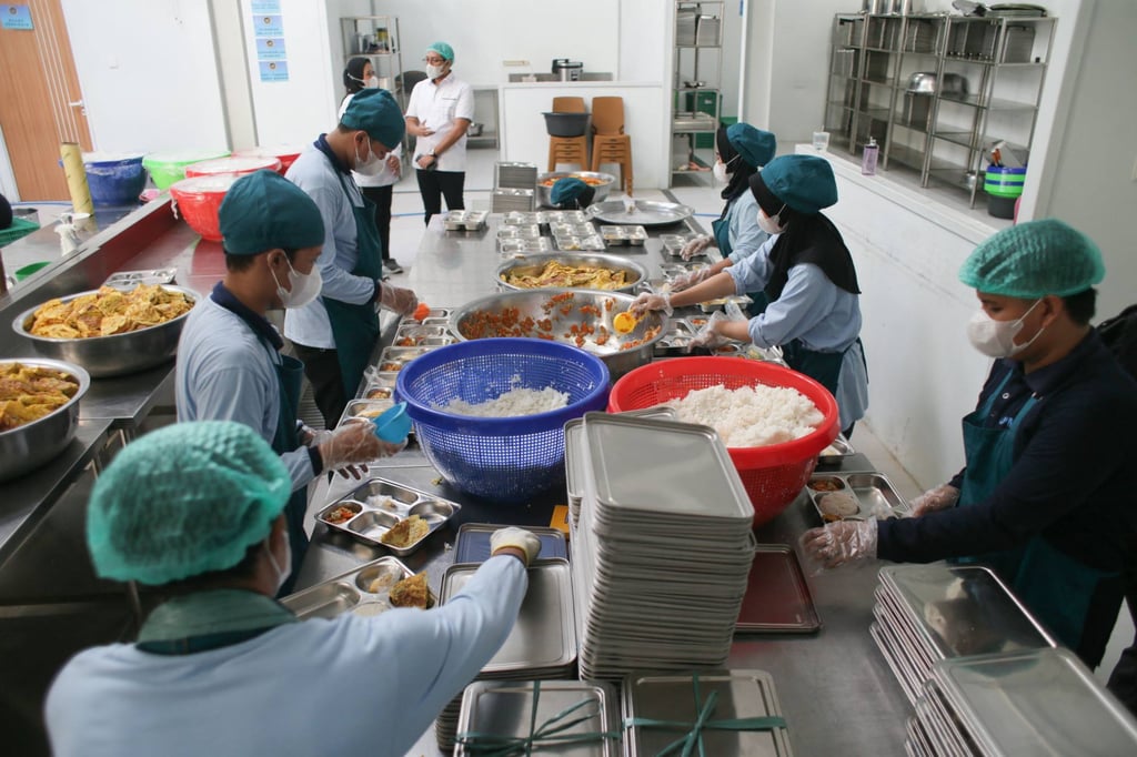 Staff prepare lunch plates on the first day of a free-meal programme at a public kitchen in Bogor, West Java, Indonesia, on January 6. Photo: AFP Staff prepare lunch plates on the first day of a free-meal programme at a public kitchen in Bogor, West Java, Indonesia, on January 6. Photo: AFP
