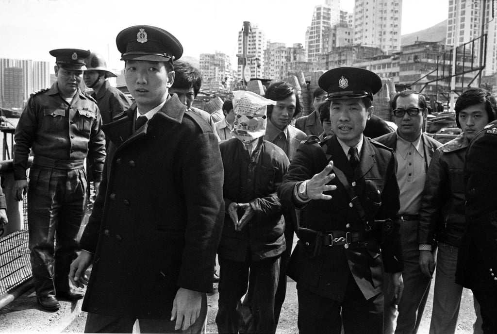 Policemen bringing a murder suspect to the Tai On Street waterfront in Shau Kei Wan, Hong Kong, to search for the limbs of a victim allegedly dumped into the sea. Photo: Yau Tin-kwai