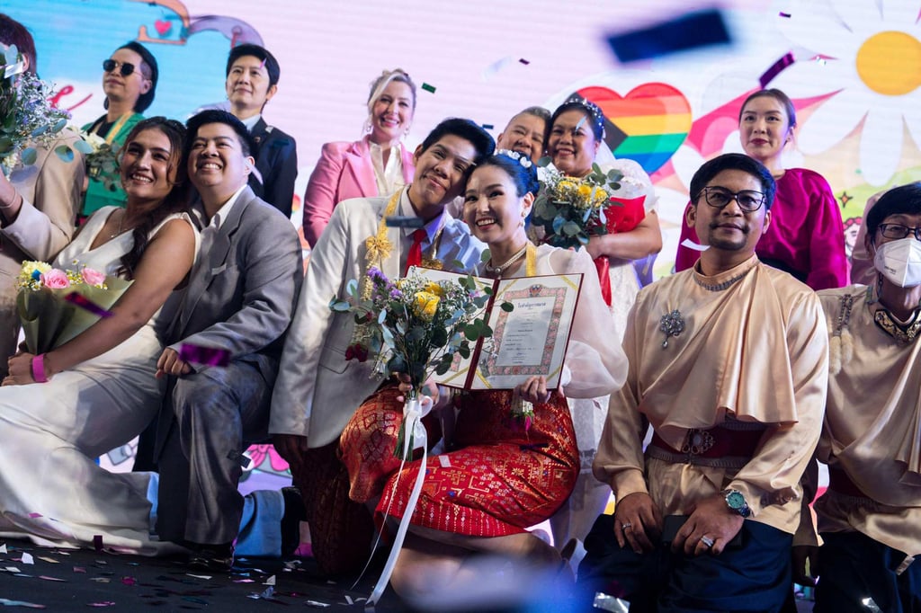 A same-sex couple (centre) poses for pictures at a marriage registration event at Paragon shopping mall in Bangkok on Thursday. Photo: AFP A same-sex couple (centre) poses for pictures at a marriage registration event at Paragon shopping mall in Bangkok on Thursday. Photo: AFP
