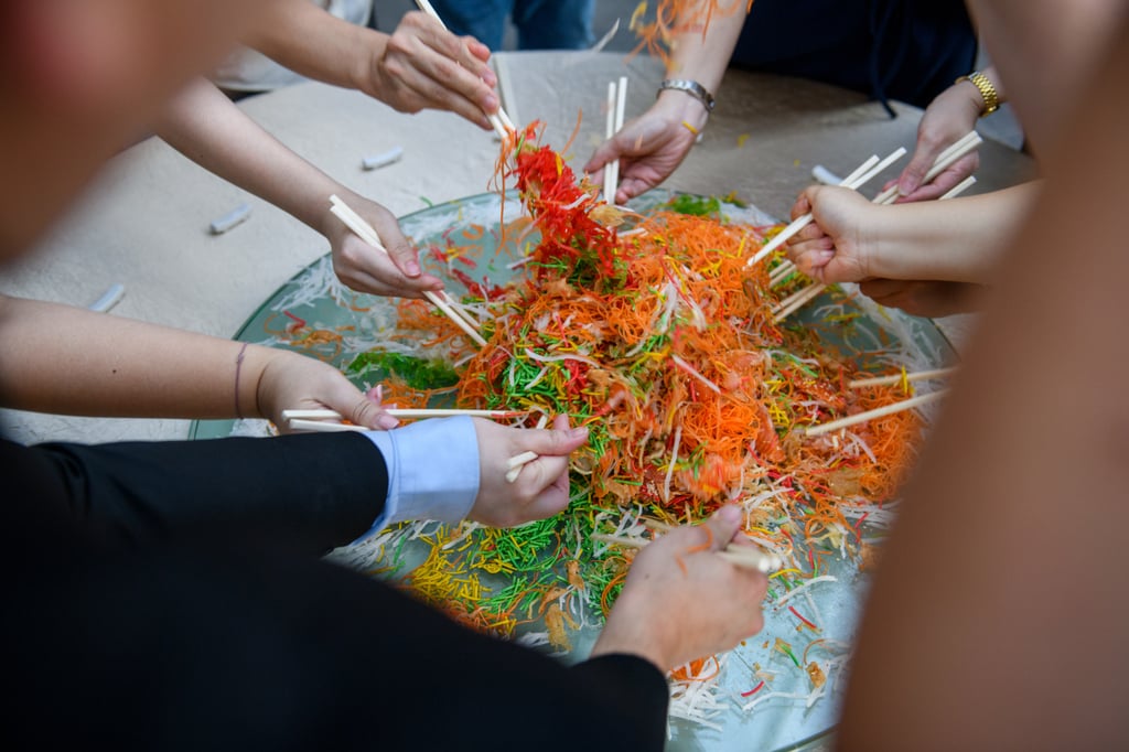 Diners toss “yusheng”, a salad of raw fish and julienne vegetables, at Chinese New Year to earn good fortune. Photo: Getty Images Diners toss “yusheng”, a salad of raw fish and julienne vegetables, at Chinese New Year to earn good fortune. Photo: Getty Images