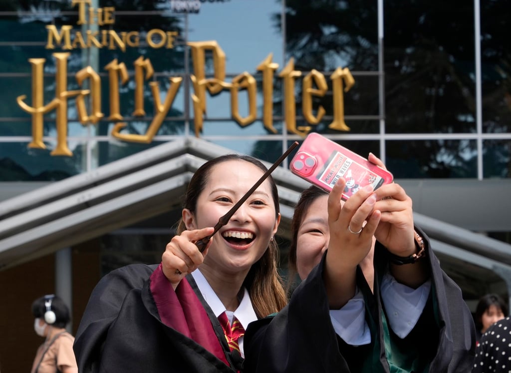 Visitors wearing costumes take selfies at the opening of a Harry Potter-themed park in Japan in 2023. Photo: EPA-EFE