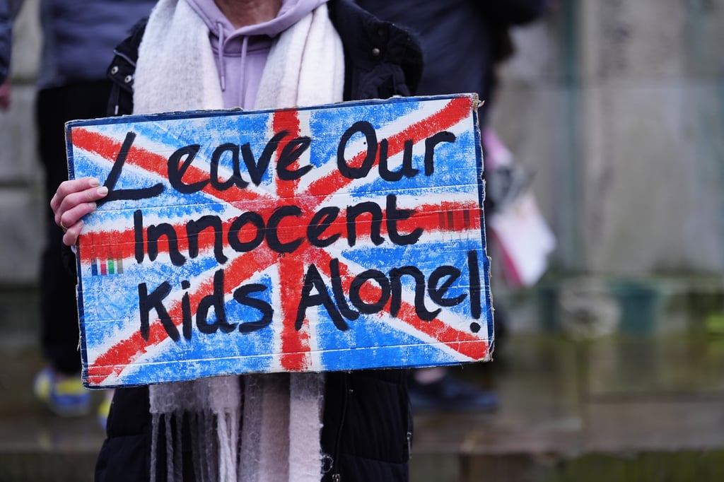 A protester holds a sign outside Liverpool Crown Court on Thursday. Photo: PA via dpa