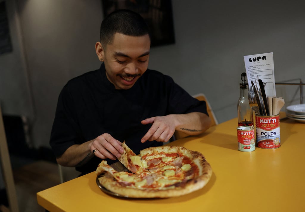 Chef Quin Jianoran and a Hawaiian pizza. Photo: Reuters Chef Quin Jianoran and a Hawaiian pizza. Photo: Reuters
