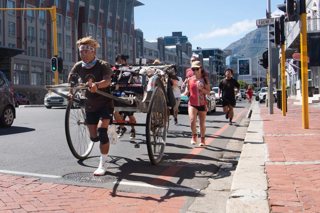 Yuji “Gump” Suzuki runs through the centre of Cape Town, South Africa, pulling his rickshaw near the end of a 6,400-kilometre journey from Nairobi, Kenya. Photo: AFP