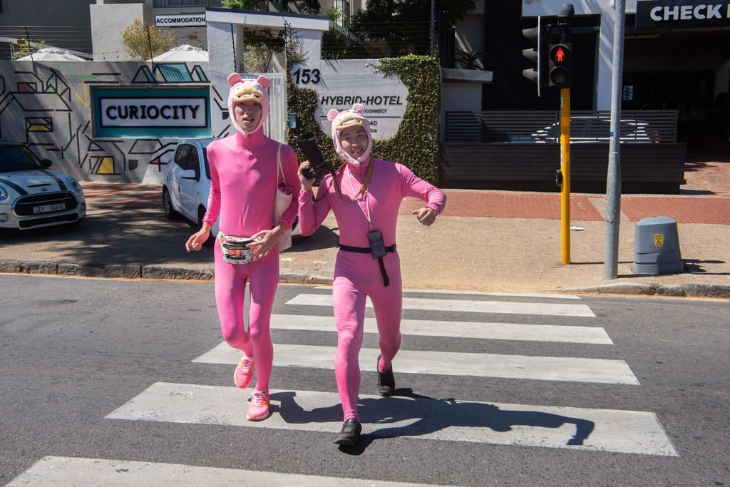 Two Japanese supporters of Suzuki cross a road to follow him on the last leg of his journey from Nairobi pulling a 100kg rickshaw. Photo: AFP