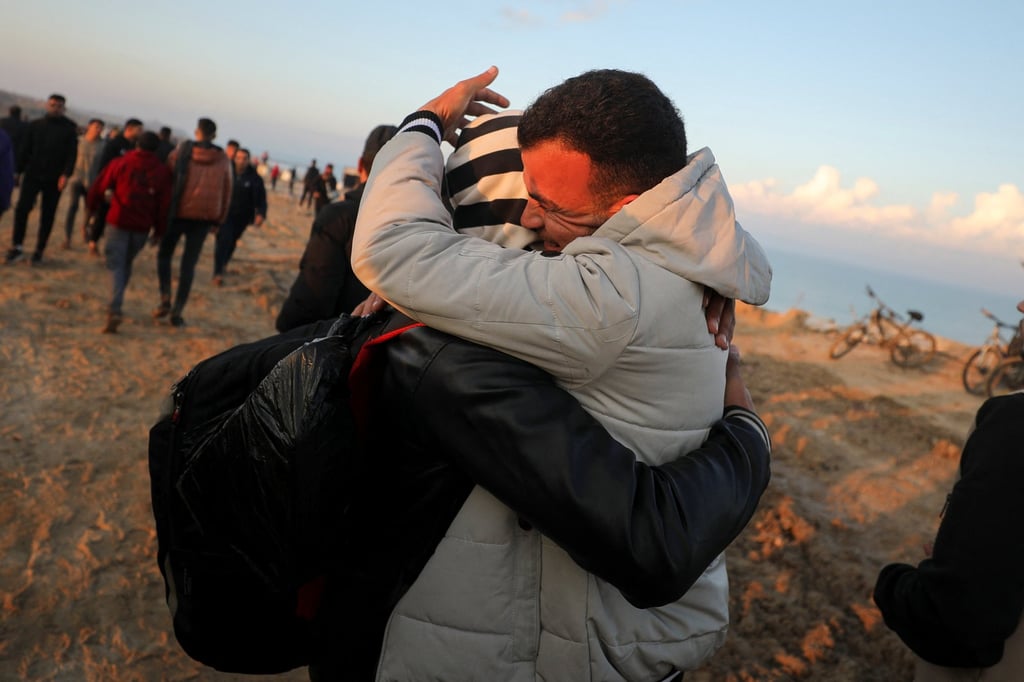 A Palestinian man is hugged while making his way back home in northern Gaza. Photo: Reuters A Palestinian man is hugged while making his way back home in northern Gaza. Photo: Reuters