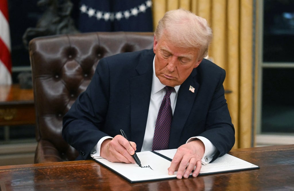 US President Donald Trump signs an executive order in the Oval Office of the White House on January 20. Photo: AFP/Getty Images/TNS