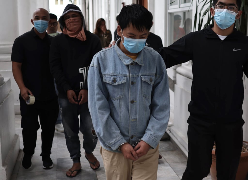 Chinese national Deng Yuanqing (second from right) with an unidentified Filipino companion (second from left) are escorted inside the Department of Justice office in Manila, the Philippines, on January 20. Photo: EPA-EFE Chinese national Deng Yuanqing (second from right) with an unidentified Filipino companion (second from left) are escorted inside the Department of Justice office in Manila, the Philippines, on January 20. Photo: EPA-EFE