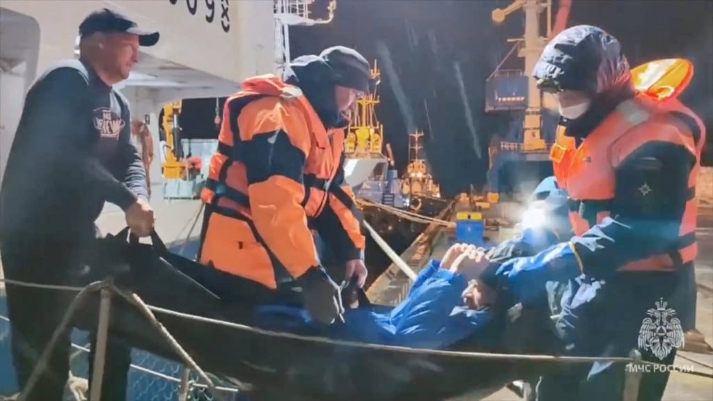 Rescuers leave a vessel in October while carrying Mikhail Pichugin, reportedly saved after his boat had drifted at sea for weeks. Photo: Handout via Reuters