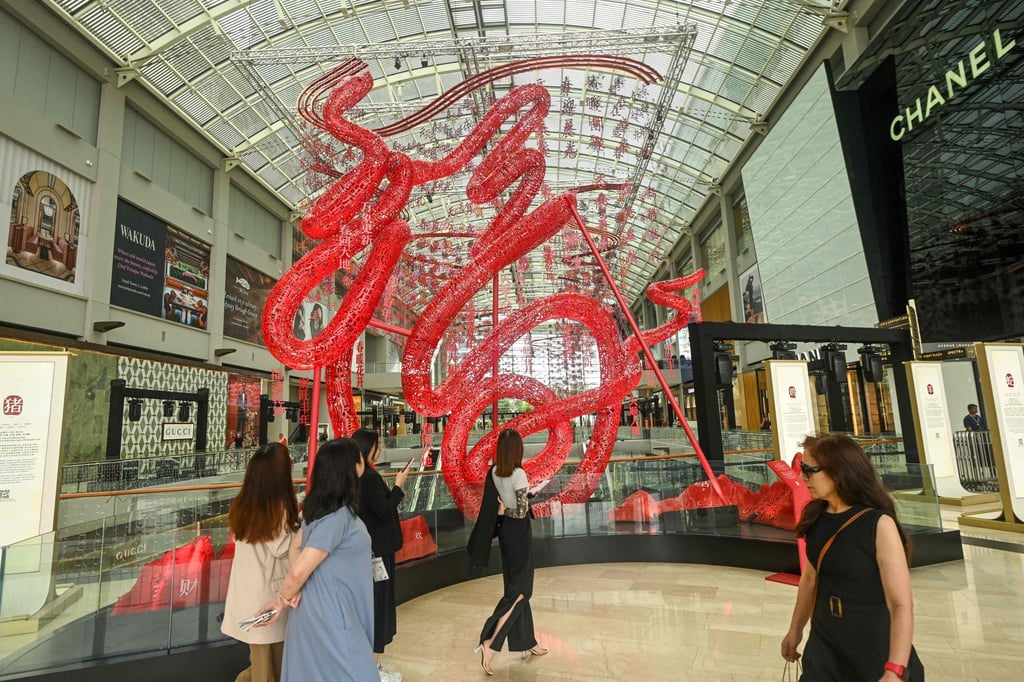 People walk past a display for the Lunar New Year of the Snake at the Marina Bay Sands shopping centre in Singapore. Photo: AFP People walk past a display for the Lunar New Year of the Snake at the Marina Bay Sands shopping centre in Singapore. Photo: AFP