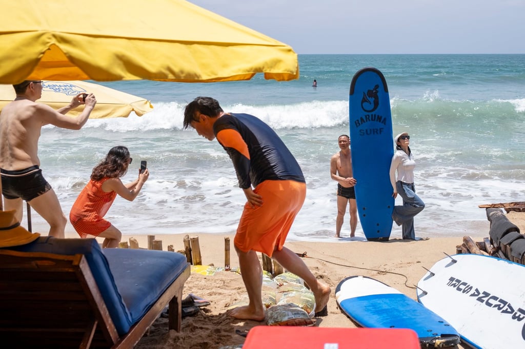 Tourists at Kuta Beach in Bali, Indonesia. More than 6.3 million international travellers visited Bali last year. Photo: EPA-EFE Tourists at Kuta Beach in Bali, Indonesia. More than 6.3 million international travellers visited Bali last year. Photo: EPA-EFE