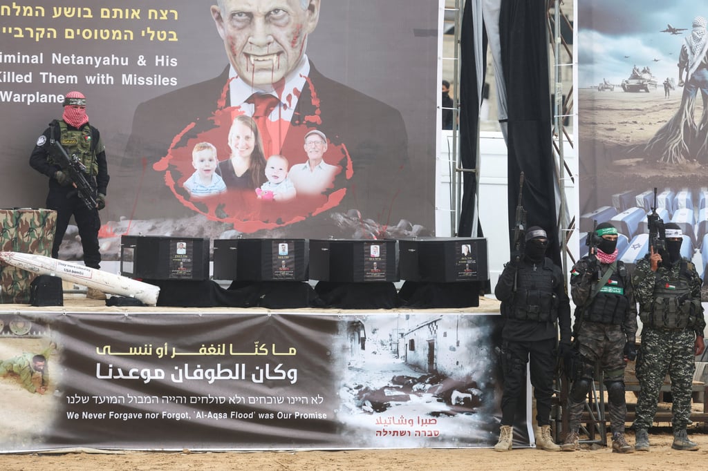 A Hamas militant stands near coffins during the handover of deceased hostages Oded Lifschitz, Shiri Bibas and her two children Kfir and Ariel Bibas. Photo: Reuters A Hamas militant stands near coffins during the handover of deceased hostages Oded Lifschitz, Shiri Bibas and her two children Kfir and Ariel Bibas. Photo: Reuters