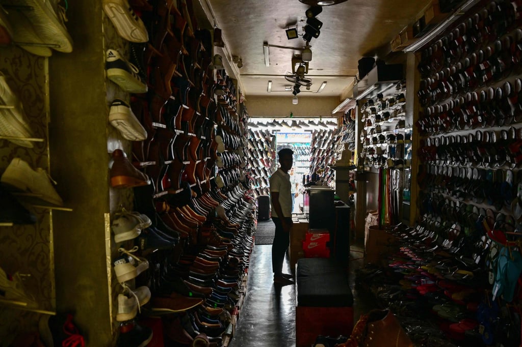 A man waits for customers at a dimmed footwear shop during a nationwide power outage in Galle, Sri Lanka, on February 9. Photo: AFP A man waits for customers at a dimmed footwear shop during a nationwide power outage in Galle, Sri Lanka, on February 9. Photo: AFP