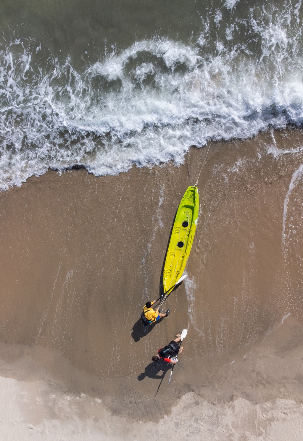 Four Peaks Race runners pull their kayak onto Lantau’s Cheung Sha Beach before running up the hill. Photo: Alexander Mak Four Peaks Race runners pull their kayak onto Lantau’s Cheung Sha Beach before running up the hill. Photo: Alexander Mak